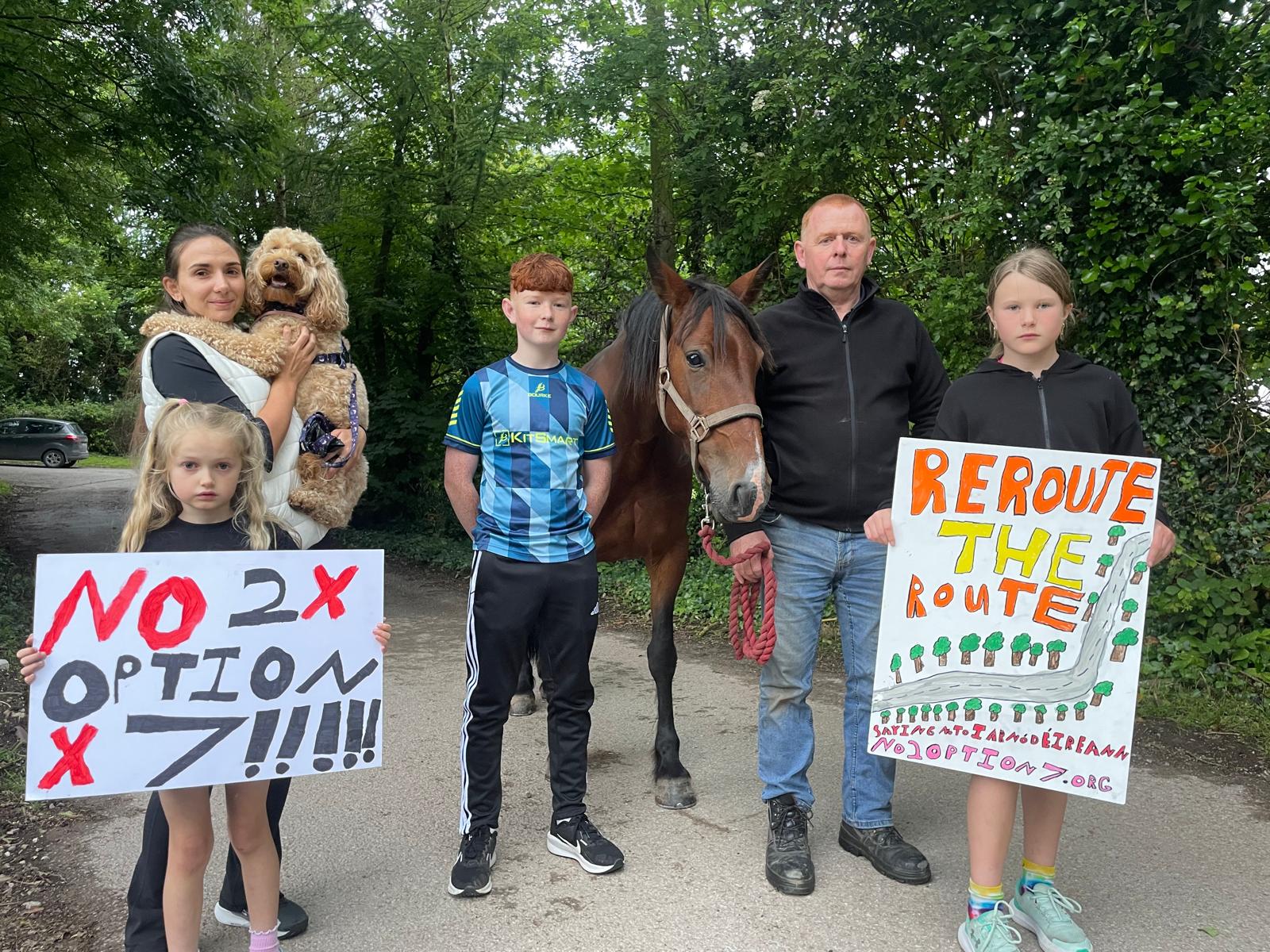 Family with horse and dog holding protest signs